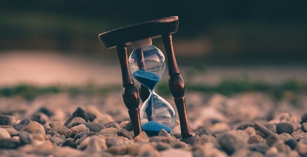 Image of hourglass amongst pebbles